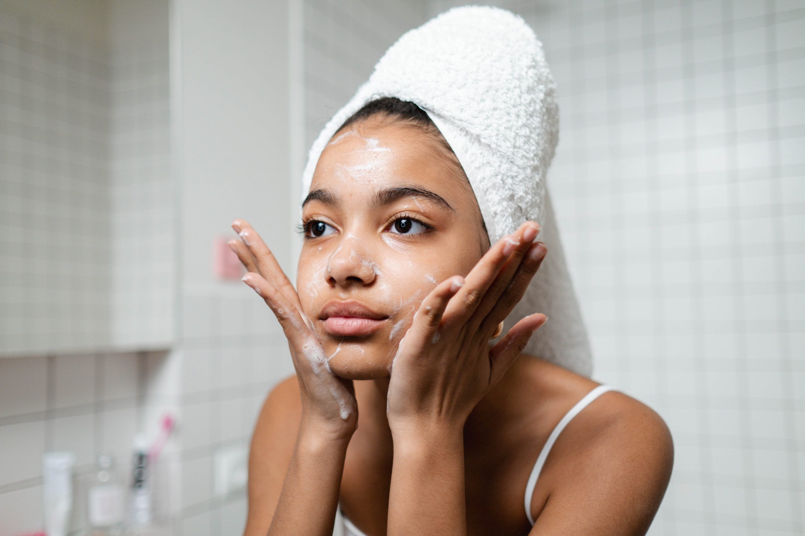 Una mujer aplica CBD sobre su cara para combatir el acné